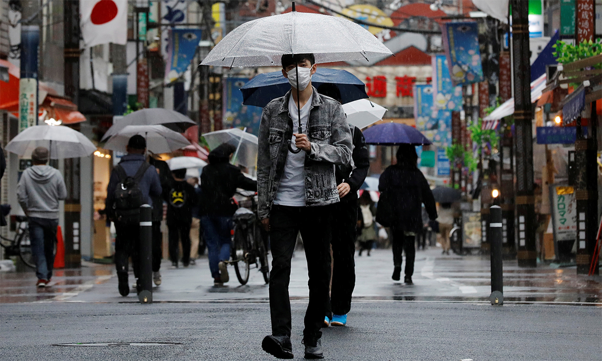 Một thanh niên Nhật Bản đeo khẩu trang đi trên đường phố thủ đô Tokyo ngày 5/5. Ảnh: Reuters