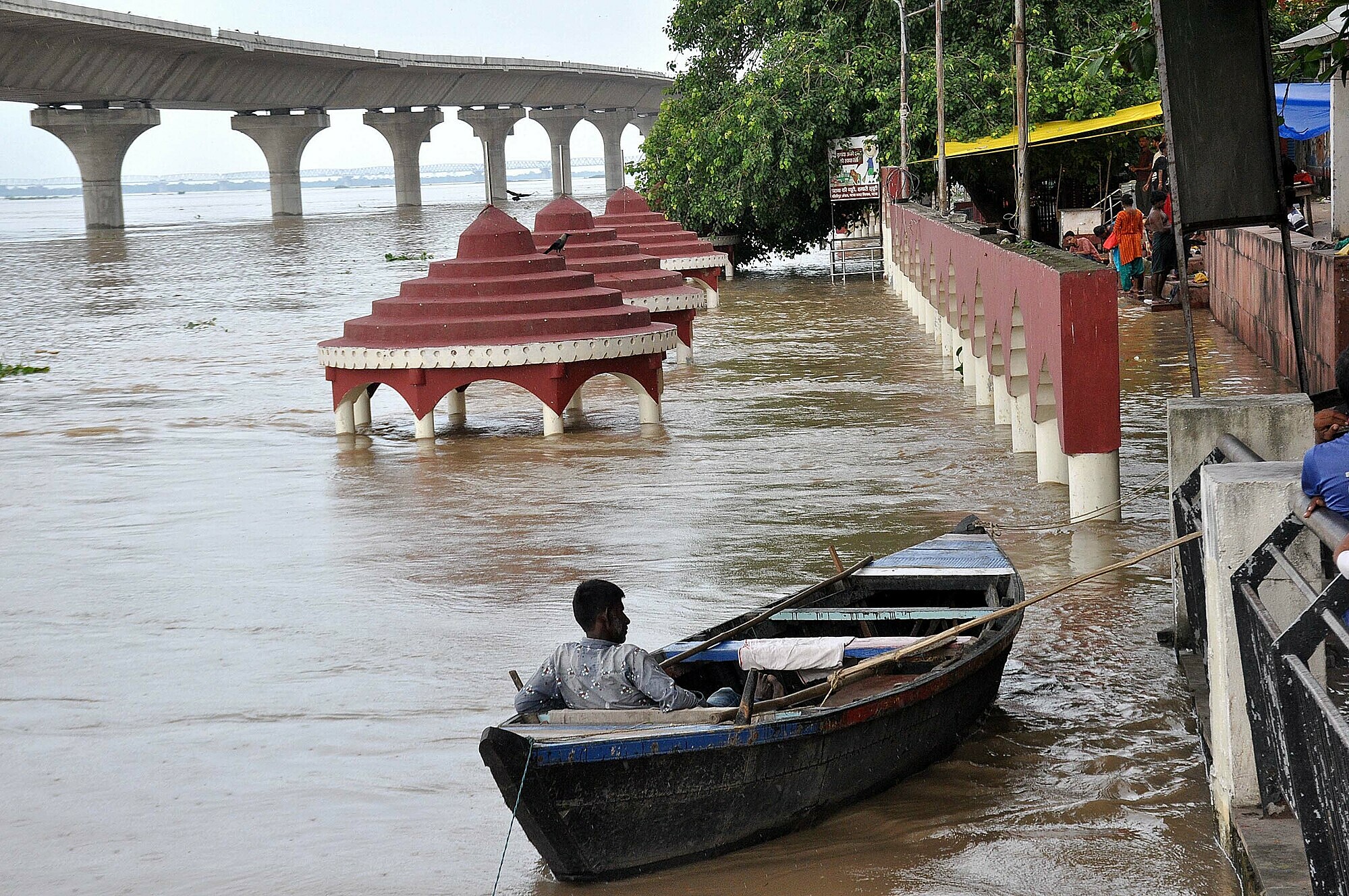 Một người đàn ông ngồi trên thuyền trong trận lũ ở Kali Ghat, bang Bihar, ngày 10/8/2021. Ảnh: AFP.