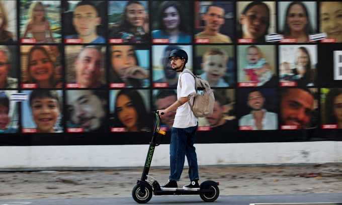 Người đàn ông đi qua bức tường treo ảnh các con tin bị Hamas bắt về Dải Gaza, ởTel Aviv, Israel, ngày 4/6. Ảnh: Reuters