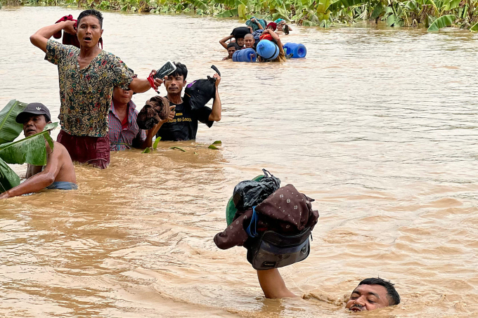 Người dân lội qua vùng nước lũ ở thị trấn Pyinmana, Myanmar ngày 13/9. Ảnh: AFP