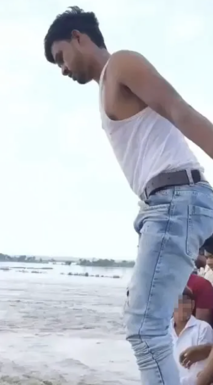 Hình ảnh Mohd Junaid, 19 tuổi, trèo qua lan can cầu trên sông Yamuna, Ấn Độ hôm 4/9, chuẩn bị nhảy xuống. Ảnh: Jam Press/TIM