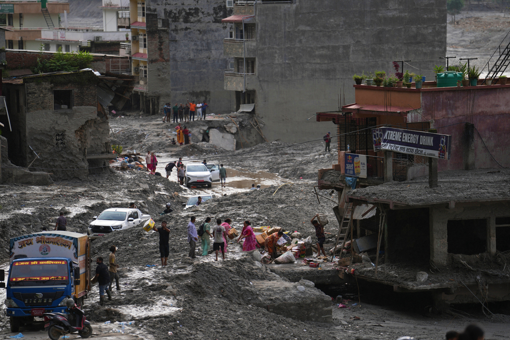 People salvage their belongings from a building damaged by flash flooding in Nuwakot district of Nepal, Tuesday, Sept. 1, 2026. (AP Photo/Rajesh Kumar Singh)