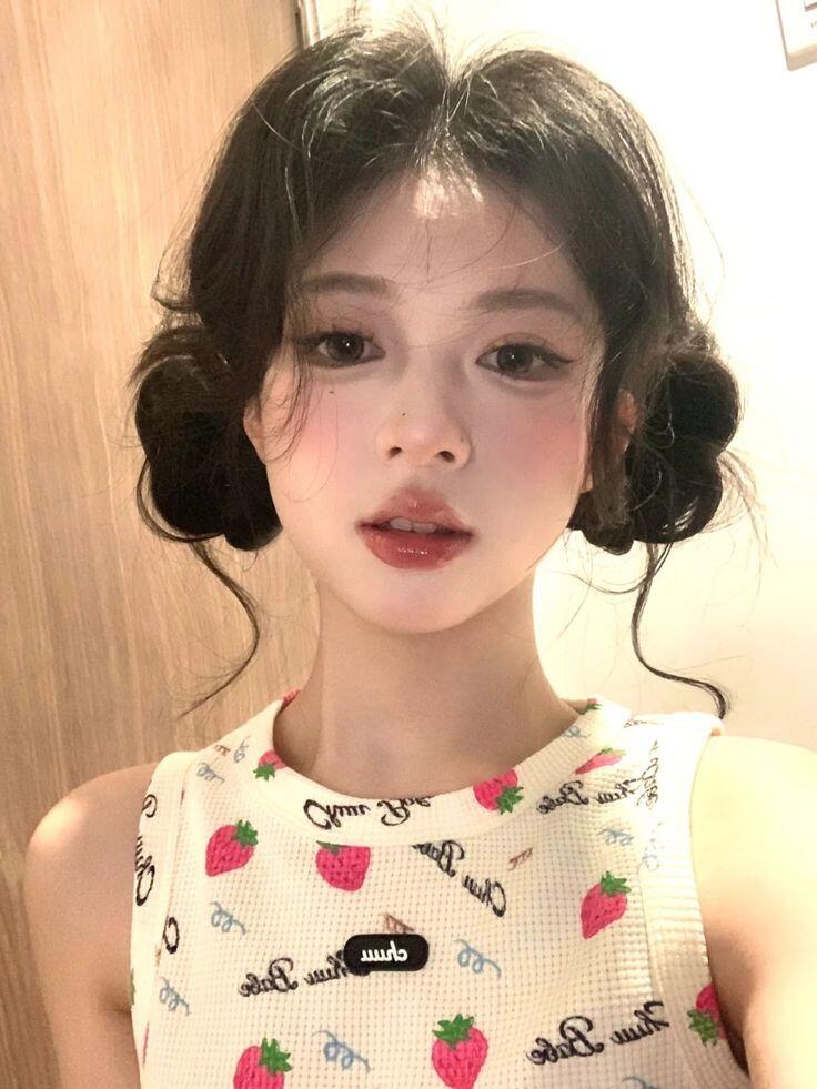 Để tăng nét nữ tính, phái đẹp có thể chia tóc thành hai bên và búi gọn, đồng thời uốn nhẹ phần mái, thả vài sợi tóc bay bay để tạo cảm giác mềm mại cho tổng thể.