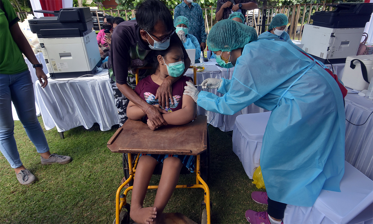 Nhân viên y tế Indonesia tiêm vaccien Covid-19 cho một phụ nữ khuyết tật trên đảo Bali ngày 7/9. Ảnh: Reuters.