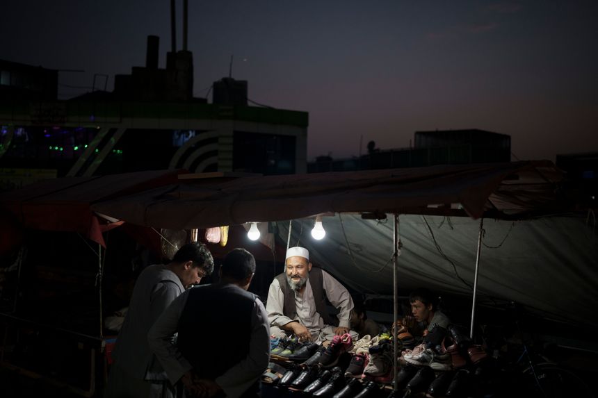 Một người bán hàng rong ở nói chuyện với khách tại khu chợ đường phố ở Kabul, Afghanistan tháng trước. Ảnh: AP.