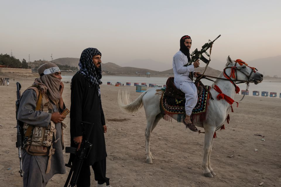 Chiến binh Taliban ôm súng cưỡi ngựa tại công viên giải trí bên hồ Qargha ở Kabul, Afghanistan, hôm 9/10. Ảnh: Reuters.