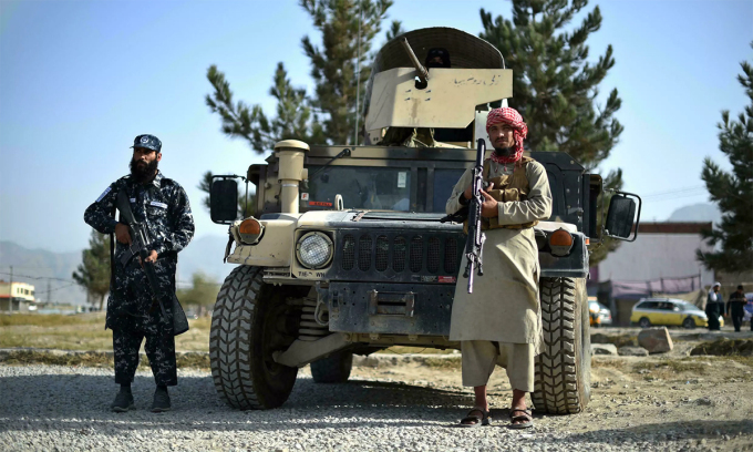 Lính Taliban đứng gác tại cổng một sở cảnh sát quận ở thủ đô Kabul, Afghanistan, ngày 3/10. Ảnh: AFP.
