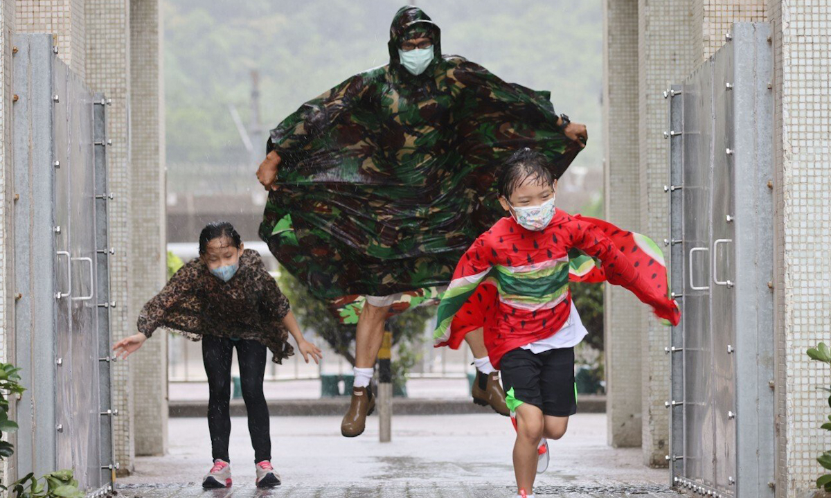 Một gia đình chạy trong mưa ở Chai Wan, Hong Kong hôm nay. Ảnh: SCMP.