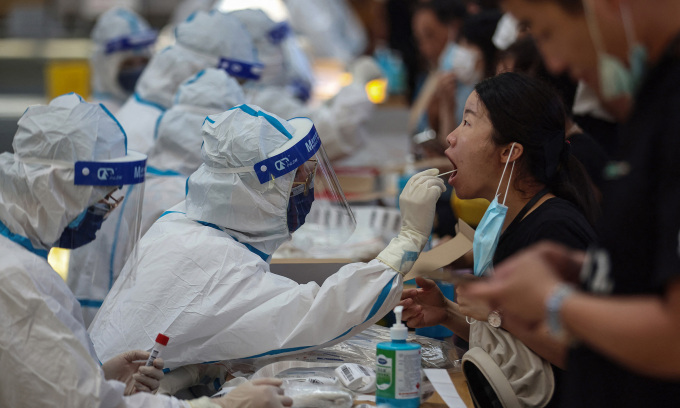 Nhân viên y tế lấy mẫu xét nghiệm nCoV cho người dân tại thành phố Nam Kinh, tỉnh Giang Tô, Trung Quốc, hôm 21/7. Ảnh: AFP.