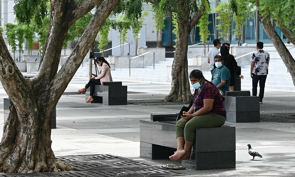 Dân Singapore ngồi nghỉ dưới tán cây tại khu tài chính ngày 21/10. Ảnh: AFP.