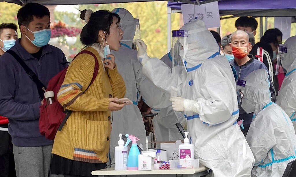 Nhân viên y tế Trung Quốc lấy mẫu xét nghiệm Covid-19 cho một người phụ nữ ở thành phố Tương Đàm, tỉnh Hồ Nam ngày 20/10. Ảnh: AFP.
