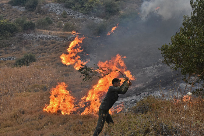 Người đàn ông đang cố dập tắt đám cháy rừng ở Hama, Syria tháng 8/2020. Ảnh: AFP.