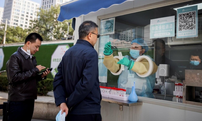 Nhân viên y tế lấy mẫu xét nghiệm nCoV cho người dân tại Bắc Kinh vào ngày 20/10. Ảnh: Reuters.
