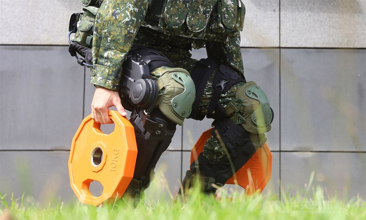 Lính phòng vệ Đài Loan nâng hai quả tạ 10 kg khi mặc khung xương trợ lực tại viện nghiên cứu ở thành phố Đào Viên ngày 26/10. Ảnh: CNA.