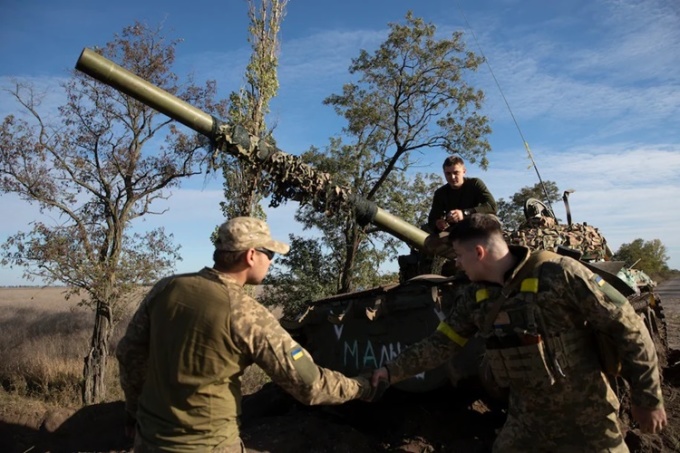 Các binh sĩ Ukraine bên một xe tăng do Nga bỏ lại ở Kherson hôm 6/10. Ảnh: Washington Post.