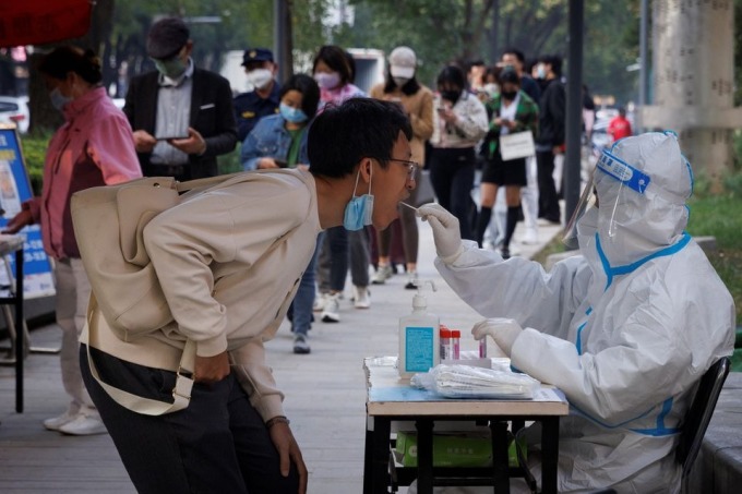 Nhân viên y tế lấy mẫu xét nghiệm Covid-19 cho người dân tại Bắc Kinh ngày 7/10. Ảnh: Reuters