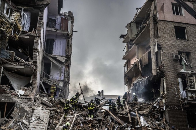 Lính cứu hỏa Ukraine tại hiện trường các tòa nhà bị phá hủy do không kích ở thành phố Zaporizhzhia ngày 10/10. Ảnh: AFP.