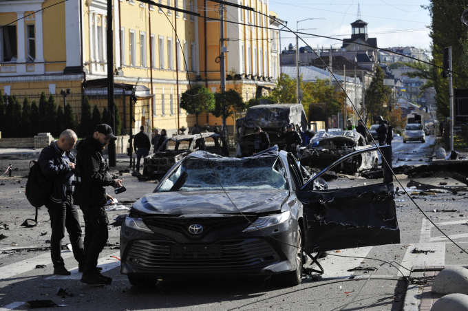 Cảnh sát đánh giá thiệt hại sau vụ tập kích ở thủ đô Kiev, Ukraine ngày 10/10. Ảnh: AFP.