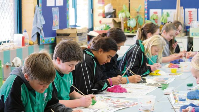 Year six student’s work hard on their masks at Koorana Primary School during art class.