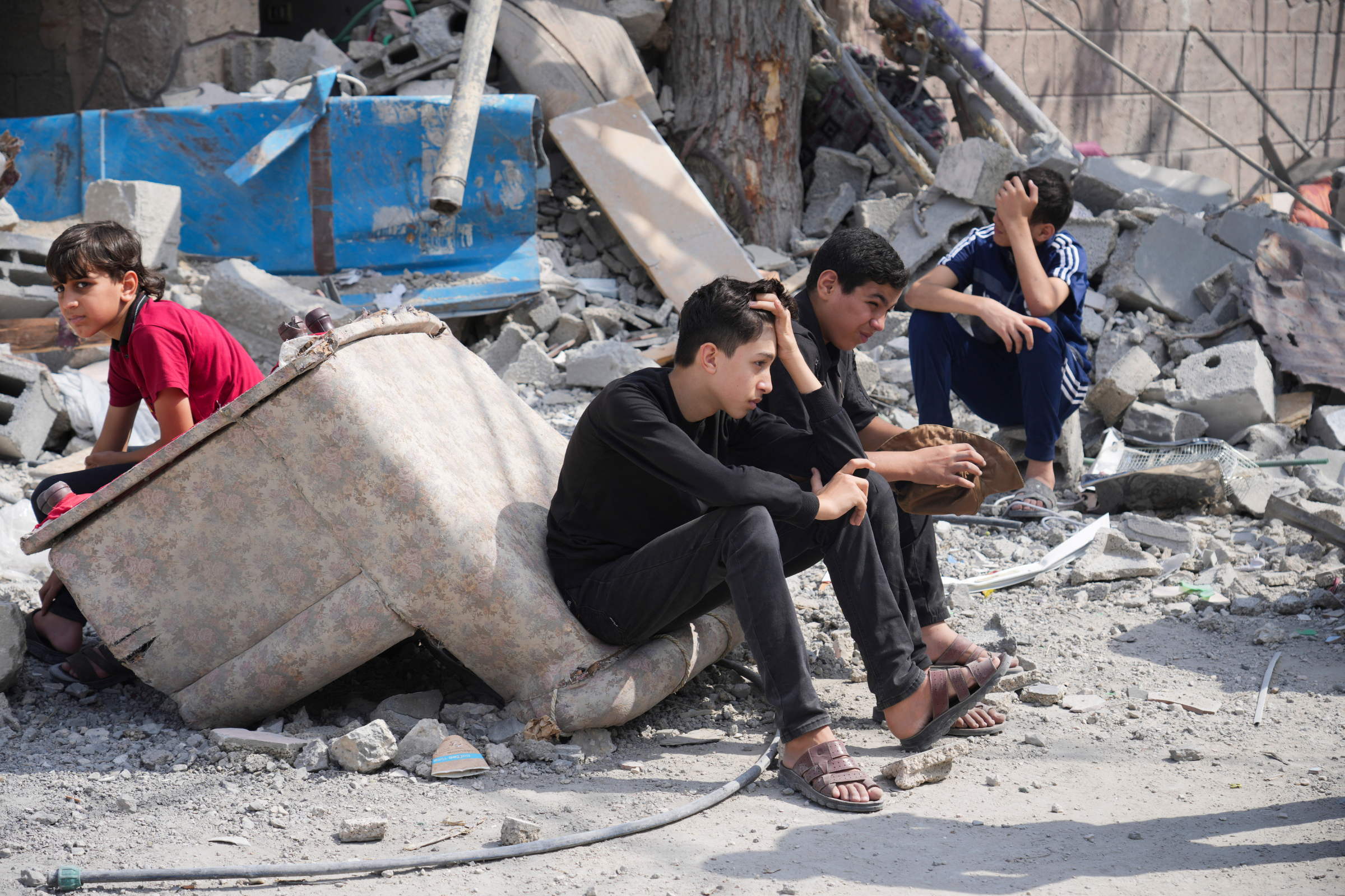 Thiếu niên Palestine ngồi trên đống đổ nát ở trại Nuseirat, miền trung Dải Gaza, ngày 19/10. Ảnh: AP