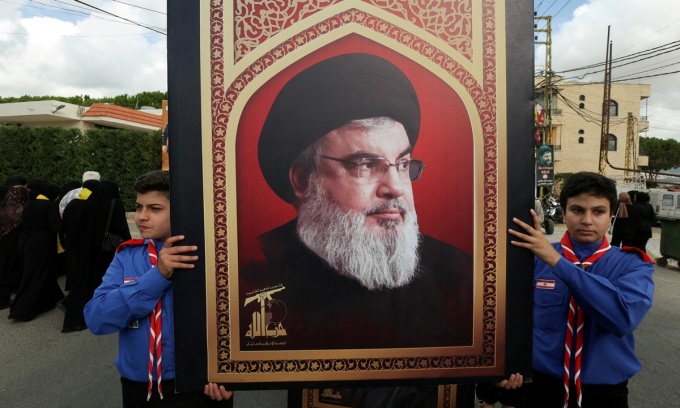 Các nam hướng đạo sinh mang theo bức ảnh thủ lĩnh Hezbollah Sayyed Hassan Nasrallah trong lễ tang một thành viên nhóm hôm 19/9. Ảnh: Reuters