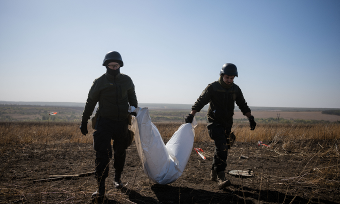 Các thành viên nhóm tình nguyện Platsdarm cầm túi đựng thi thể phát hiện được ở Dolyna, Donetsk hôm 1/10. Ảnh: AFP