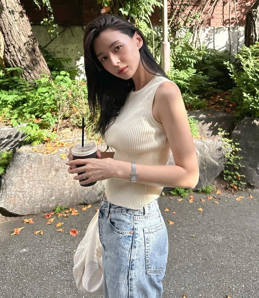 Kwon Nara biến áo ba lỗ thành món đồ “signature” của mình. Không phô trương nhưng vẫn gợi cảm, cô luôn chọn thiết kế ôm dáng, gam màu nhã nhặn và cách phối tối giản. Vẻ đẹp từ sự tiết chế ấy khiến mỗi khung hình của Nara đều toát lên phong thái tinh tế, sang chảnh đầy tự nhiên.