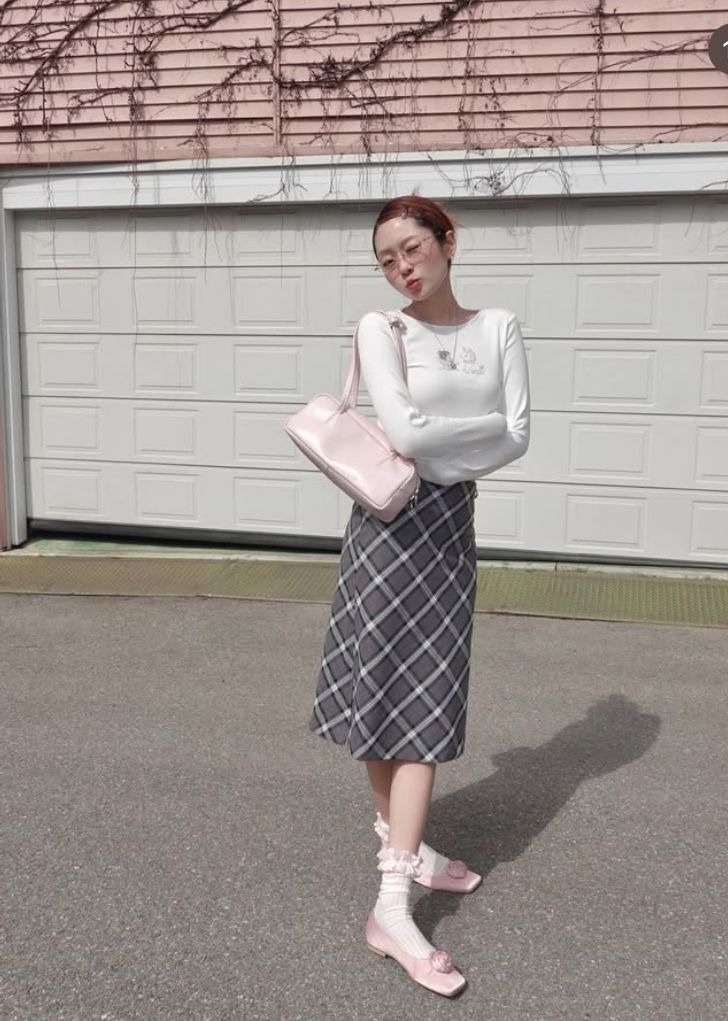 Chân váy midi dáng chữ A xòe nhẹ đang lên ngôi, thay thế kiểu váy xòe rộng của mùa hè. Dáng váy gọn gàng giúp người mặc tôn chiều cao, tạo vẻ thanh lịch. Các bạn trẻ thường chọn giày búp bê, tất bèo nhún hoặc sneakser.