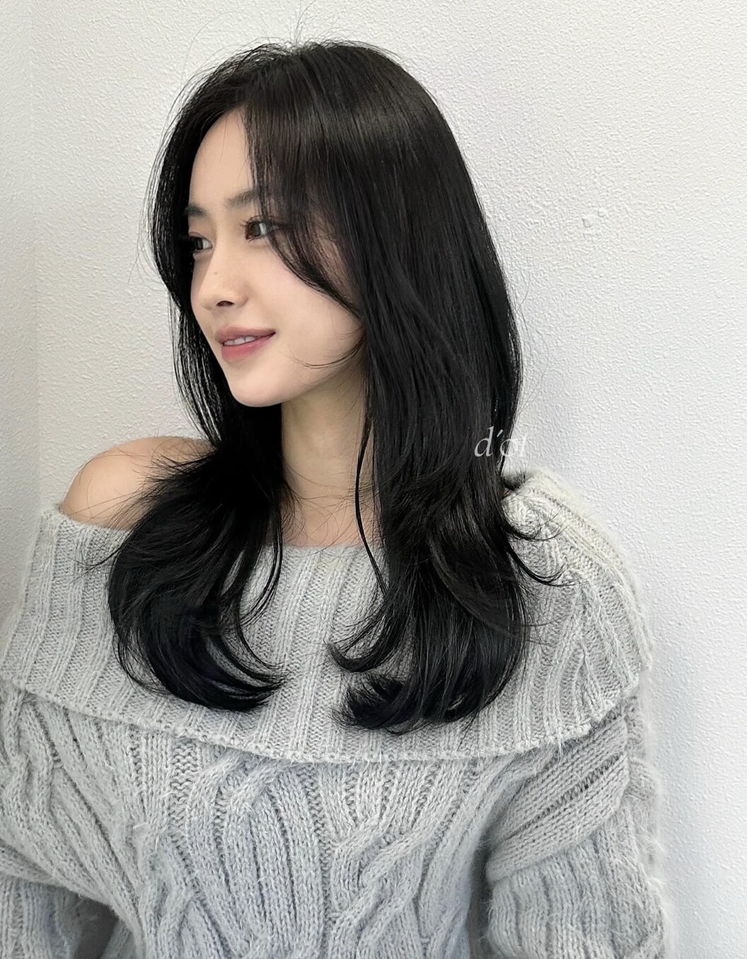 Tóc layer giúp tạo hiệu ứng ôm mặt nhẹ nhàng, giúp gương mặt tròn trông gọn và cân đối hơn. Mái dài rẽ ngôi khéo léo che phần má đầy, đồng thời tạo sự mềm mại cho tổng thể. Tóc đen giúp kiểu này thêm thanh lịch và phù hợp mọi phong cách.