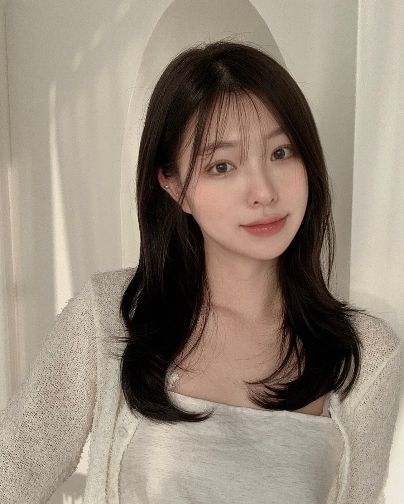 Tóc lửng dài qua vai nhẹ nhàng giúp cân đối tỉ lệ gương mặt tròn. Khi kết hợp cùng màu tóc đen, kiểu tóc này mang lại vẻ ngoài tự nhiên, nền nã và trưởng thành. Bạn có thể để thẳng, uốn nhẹ hoặc thêm mái để tạo điểm nhấn cho gương mặt.