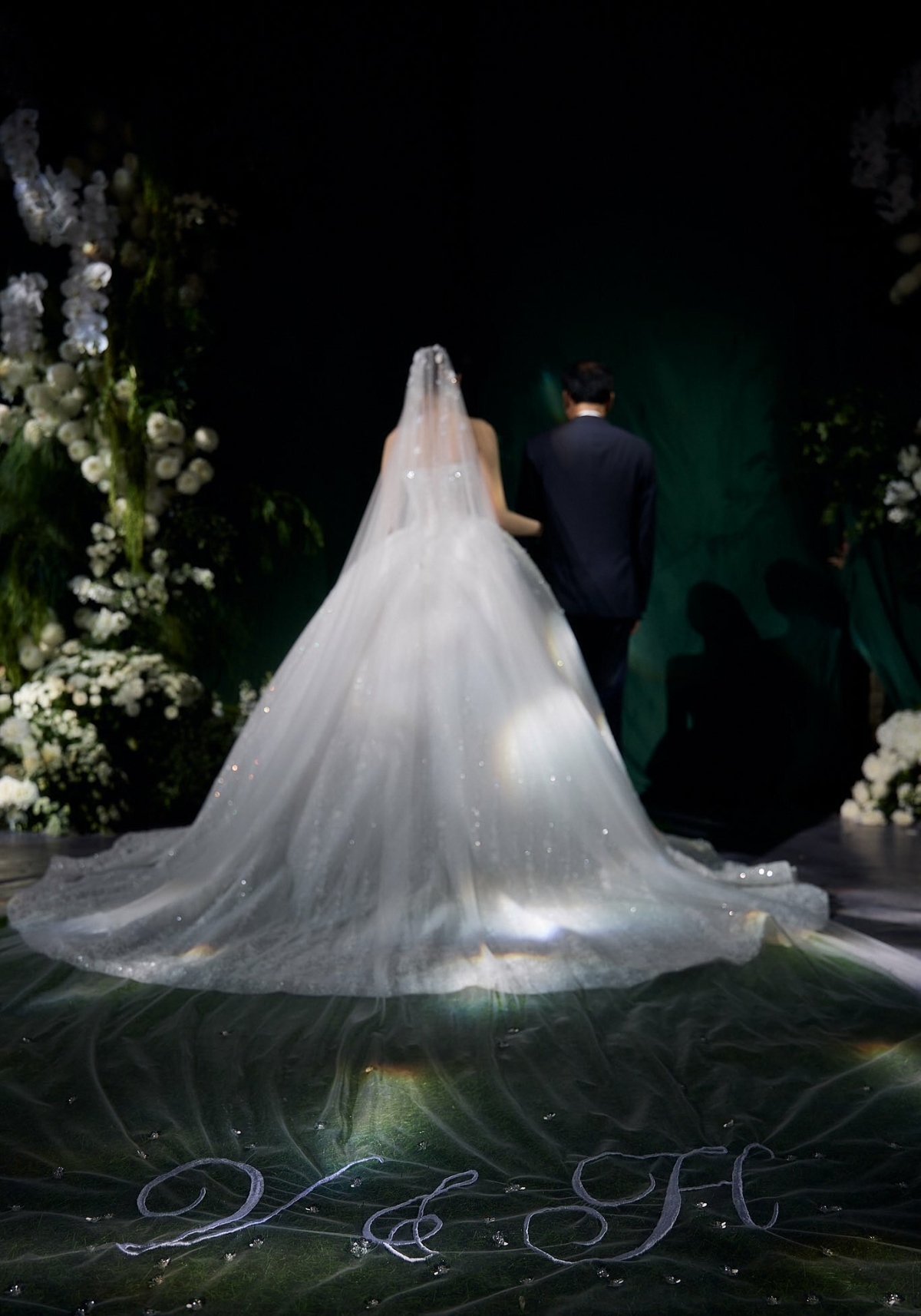 Điểm nhấn đặc biệt nằm ở veil dài hơn 4 mét, thêu tay chữ H và V - viết tắt của Đỗ Hà và Viết Vương - biểu trưng cho sự gắn kết trọn đời.