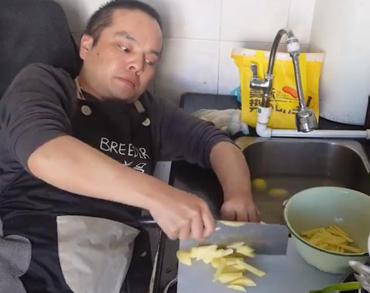 Trương Hiểu Đông ngồi trên xe lăn để nấu nướng. Ảnh: cctv.