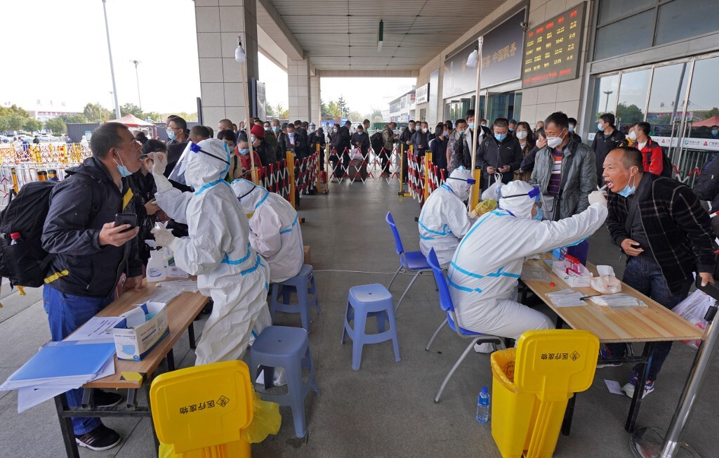 Nhân viên y tế lấy mẫu xét nghiệm Covid-19 cho hành khách tại một nhà ga ở tỉnh Sơn Đông, Trung Quốc hôm 2/11. Ảnh: AFP.