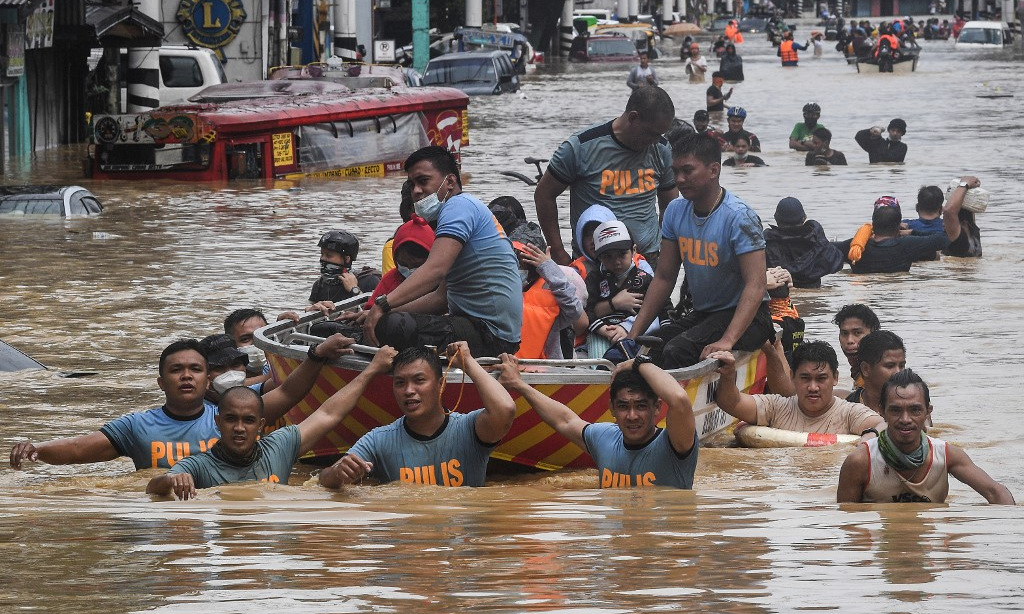 Cảnh sát hỗ trợ người mắc kẹt vì bão Vamco ở ngoại ô Manila, Philippines, hồi tháng 11/2020. Ảnh: AFP.