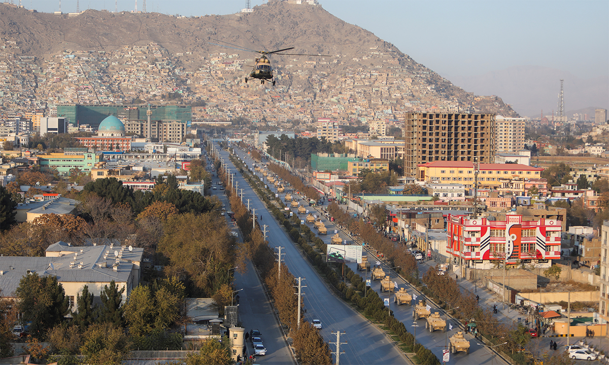 Trực thăng Mi-17 bay phía trên đoàn xe thiết giáp M117 trong lễ duyệt binh của Taliban tại Kabul, Afghanistan ngày 14/11. Ảnh: Reuters.