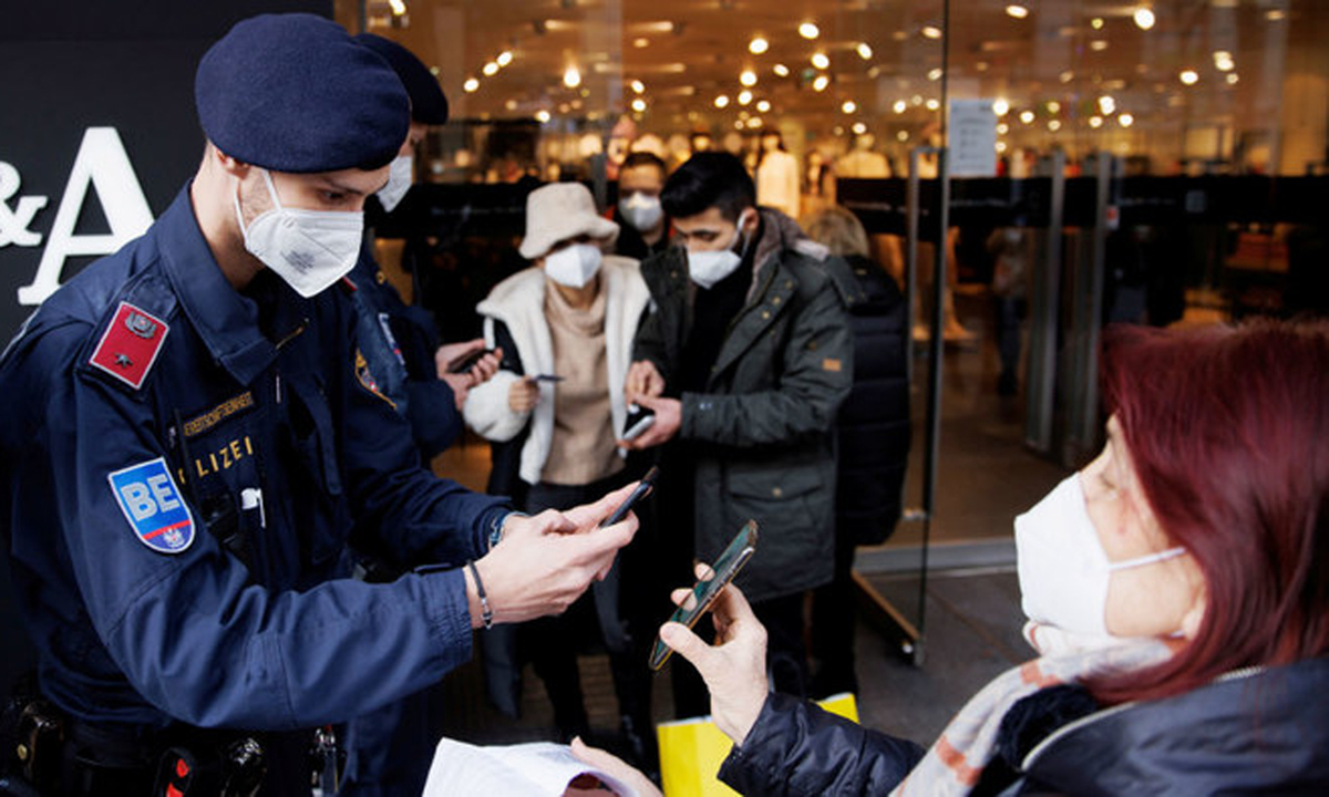 Cảnh sát kiểm tra giấy chứng nhận tiêm chủng trước một cửa hàng ở Vienna, Áo tuần trước. Ảnh: Reuters.