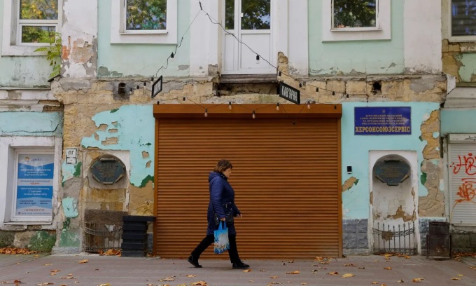 Người phụ nữ đi trên một con phố ở Kherson, miền nam Ukraine hôm 31/10. Ảnh: Reuters.