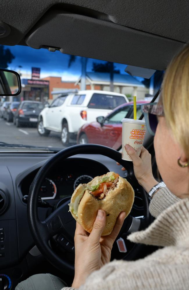 Queenslanders risk a $575 when they eat behind the wheel. Photo: Rob Williams