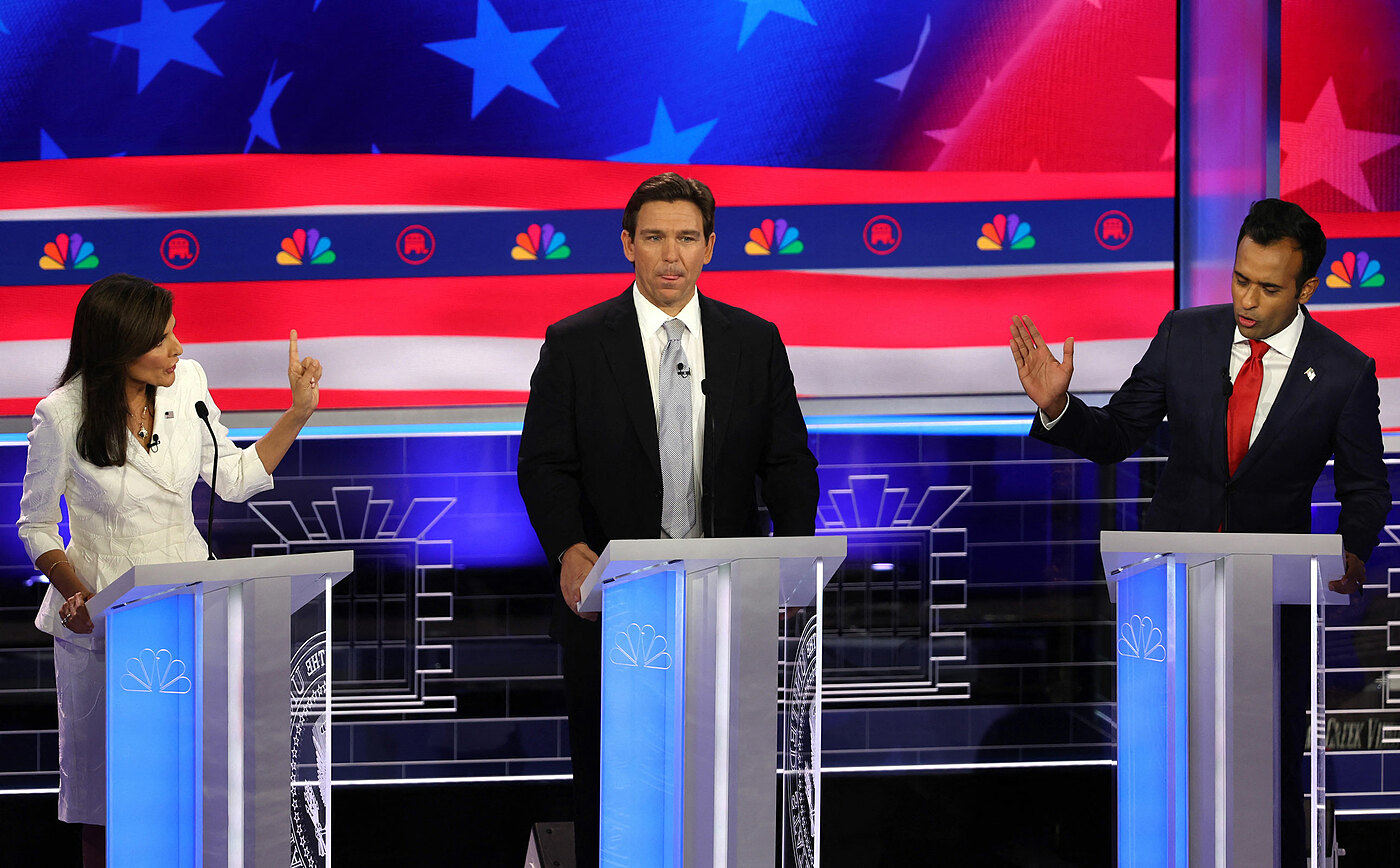 Florida Gov. Ron DeSantis listens as former South Carolina Gov. Nikki Haley and Vivek Ramaswamy argue on either side of him on Wednesday in Miami. Mike Segar/Reuters