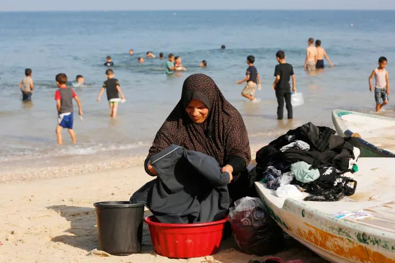 Andaleeb giặt đồ cho gia đình bằng nước biển ở Deir al-Balah, phía nam Gaza. Ảnh: Al Jazeera