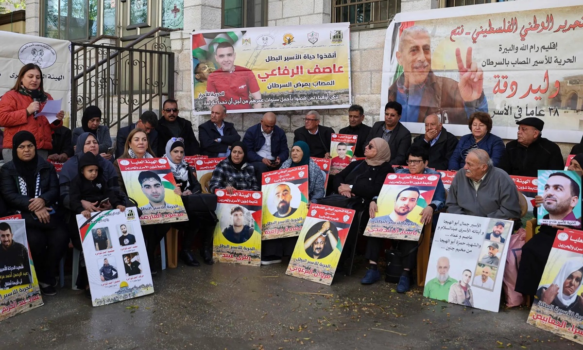 Nhóm vận động yêu cầu trả tự do cho những người Palestine bị giam trong các nhà tù Israel tổ chức biểu tình ngồi trước Hội Chữ thập Đỏ ở thành phố Ramallah, khu vực Bờ Tây hôm 21/11. Ảnh: AFP