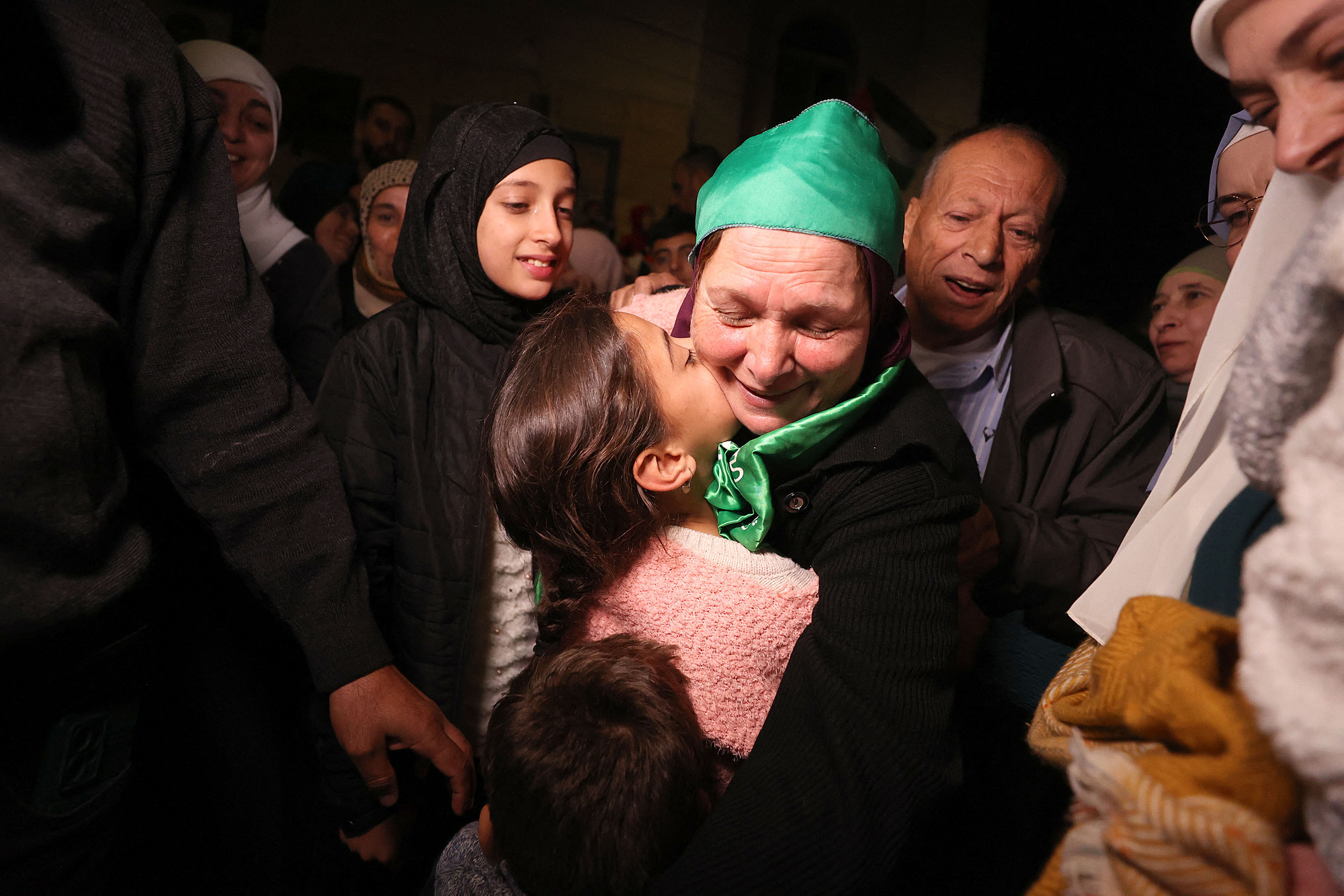 Tù nhân Palestine (đầu quấn khăn xanh) ôm người thân sau khi trở về Beitunia, phía tây Ramallah, ngày 24/11. Ảnh: AFP
