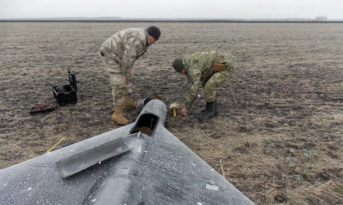 Binh sĩ Ukraine đứng cạnh xác UAV Nga ngày 26/1. Ảnh: Reuters