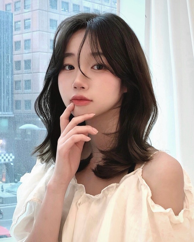 Kiểu tóc ngang vai layer tạo độ phồng tự nhiên, giúp mái tóc dày và sống động hơn. Những tầng tóc tỉa khéo léo giúp gương mặt thon gọn, che khuyết điểm tốt. Kết hợp cùng màu nhuộm sáng như nâu tây hay caramel, chị em sẽ trông sành điệu, tươi tắn và cực “Hàn”.