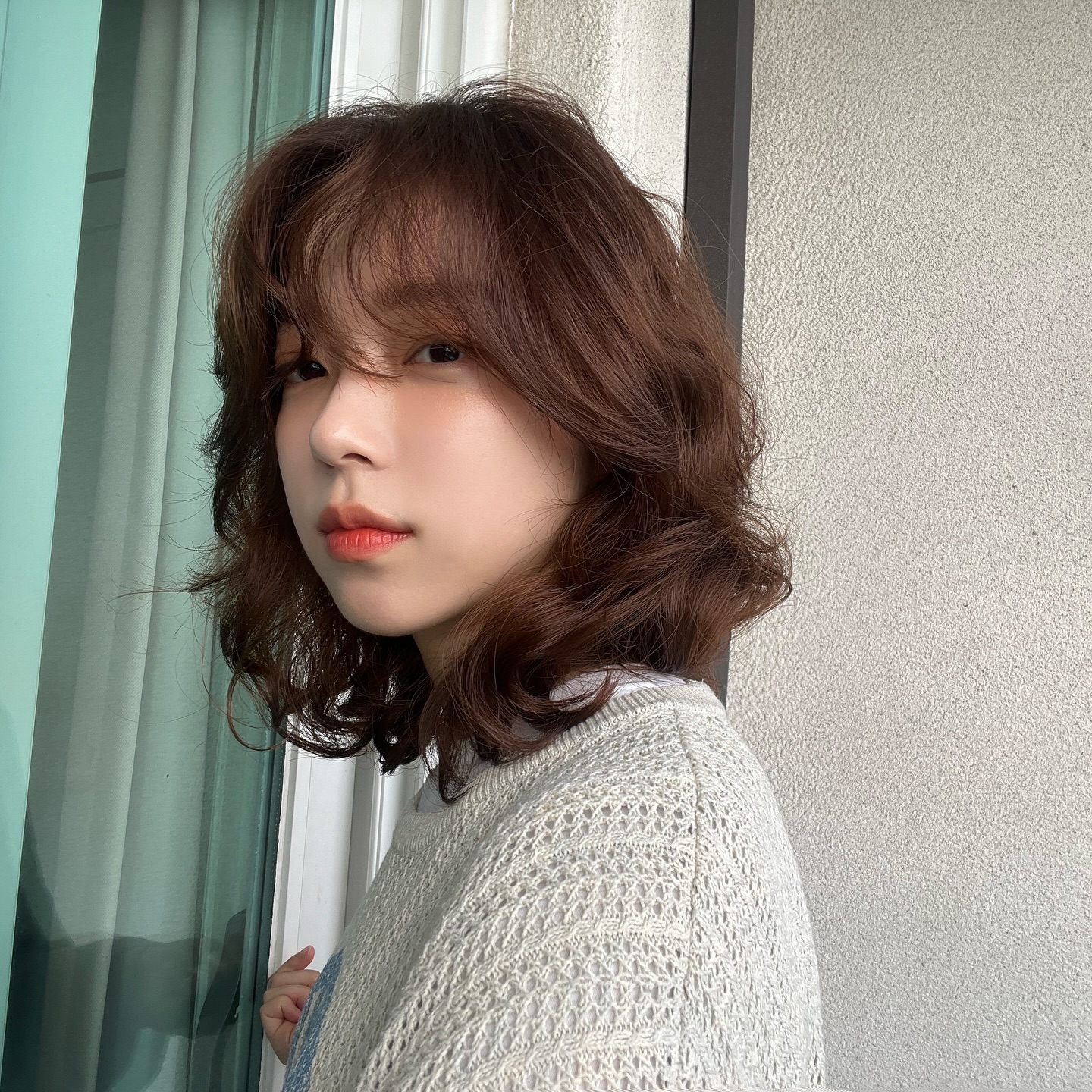 Tóc ngắn xoăn giúp gương mặt trẻ trung, năng động và hiện đại hơn. Những lọn xoăn nhỏ hoặc xoăn nhẹ tạo độ phồng tự nhiên, che khuyết điểm má bầu và đường jawline to rất hiệu quả. Kiểu tóc này dễ chăm, chỉ cần bóp dưỡng nhẹ là tóc vào nếp đẹp cả ngày.