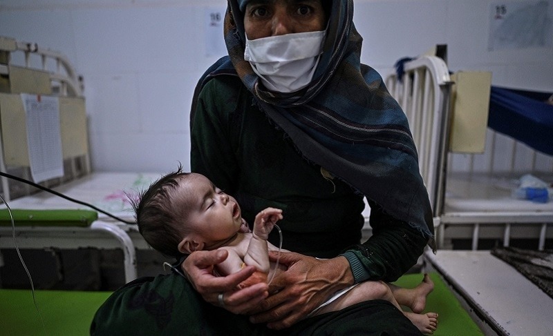 Edi Maa bế con đang điều trị suy dinh dưỡng trong trung tâm của MSF tại Herat ngày 22/11. Ảnh: AFP