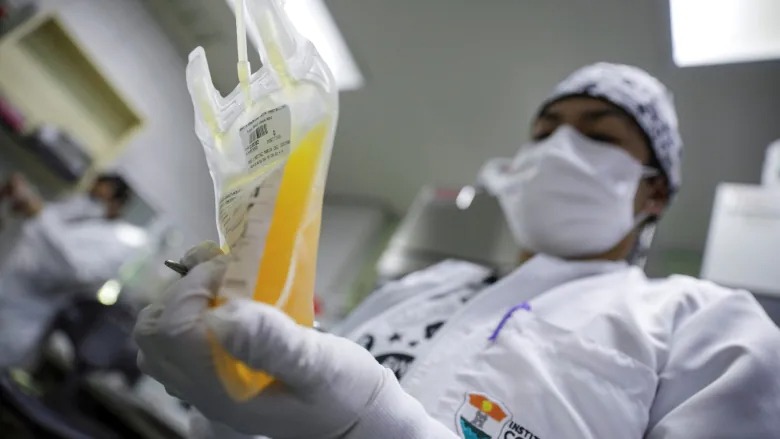 Kỹ thuật viên phòng thí nghiệm cầm túi huyết tương dưỡng do người khỏi Covid-19 hiến tặng tại một ngân hàng máu ở Toluca, Mexico hồi tháng 2. Ảnh: Reuters.