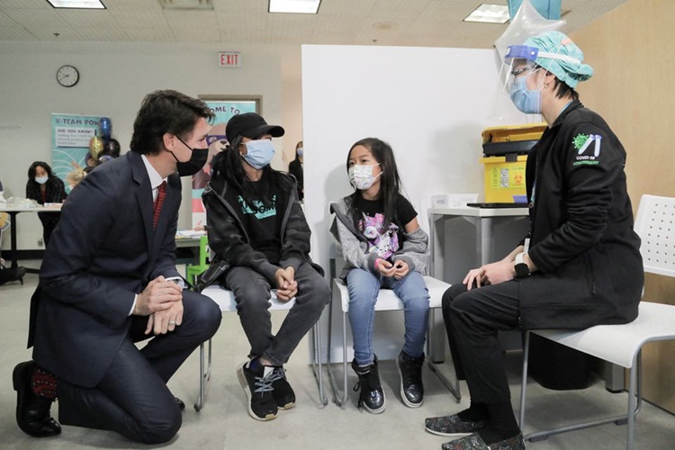 Thủ tướng Canada Justin Trudeau (ngoài cùng bên trái) thăm một đơn vị tiêm chủng Covid-19 ở Ontario, hôm 10/12. Ảnh: Reuters.