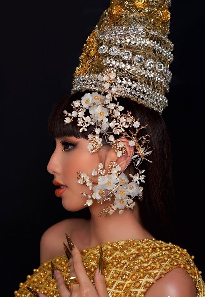 Trước khi đi thi, Thùy Tiên cũng thể hiện sự yêu thích văn hóa, thời trang nước bạn. Cô thực hiện bộ ảnh hóa thân thành công chúa xử sở Chùa Vàng.