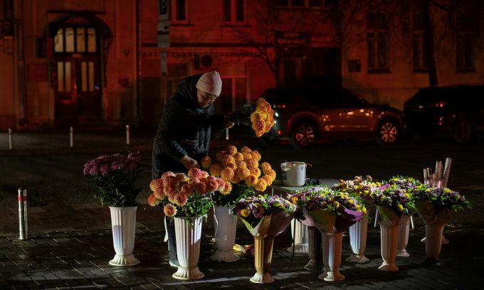 Một người bán hoa giữa đường phố tối tắm ở thủ đô Kiev, Ukraine hôm 13/11. Ảnh: Washington Post.